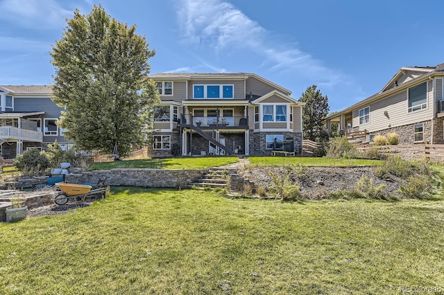 back of house featuring a lawn and a balcony