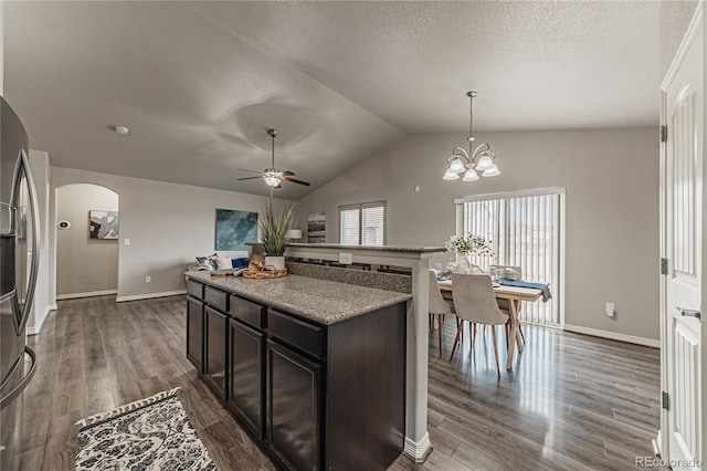 kitchen with dark brown cabinetry, stainless steel fridge with ice dispenser, pendant lighting, and dark wood-type flooring