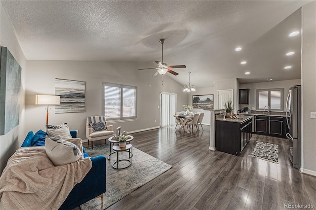 living room with ceiling fan, dark wood-type flooring, vaulted ceiling, and a textured ceiling