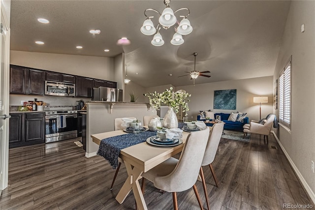 dining room with vaulted ceiling, ceiling fan with notable chandelier, and dark hardwood / wood-style flooring