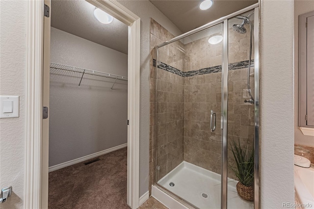 bathroom featuring an enclosed shower and a textured ceiling