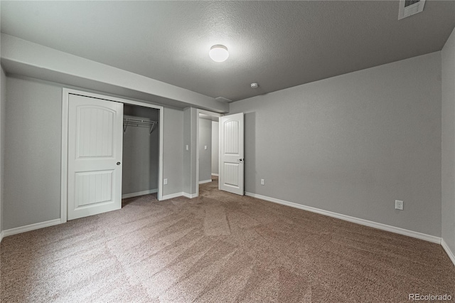 unfurnished bedroom featuring carpet flooring, a textured ceiling, and a closet