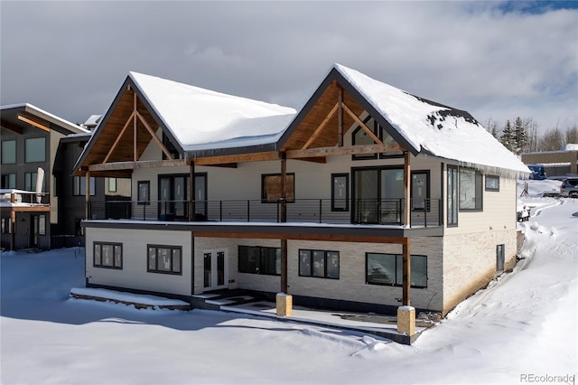 snow covered rear of property featuring french doors