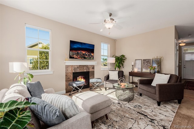 living room featuring ceiling fan, a wealth of natural light, a premium fireplace, and carpet flooring