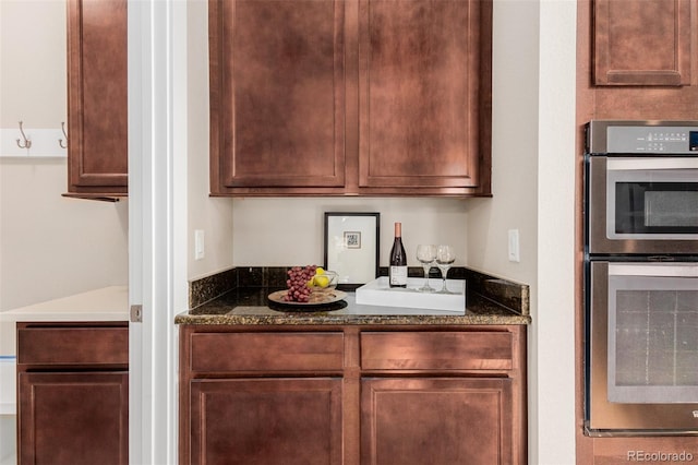 kitchen with dark stone counters and stainless steel double oven