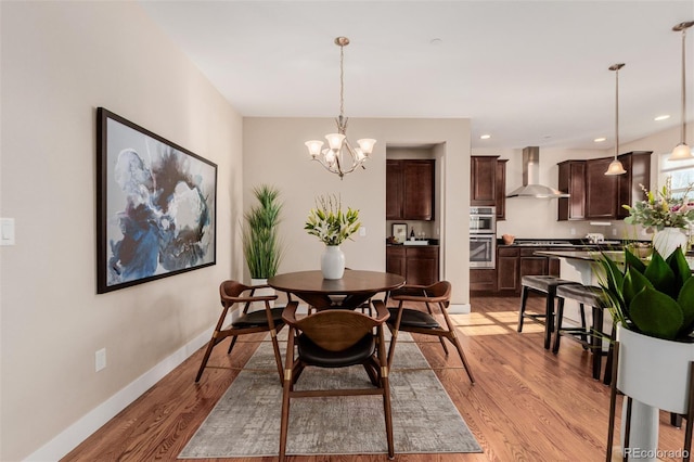 dining area featuring light hardwood / wood-style floors and a chandelier