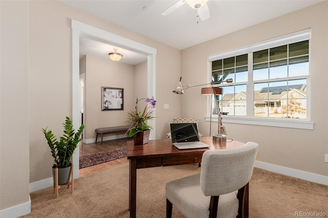 carpeted office featuring ceiling fan