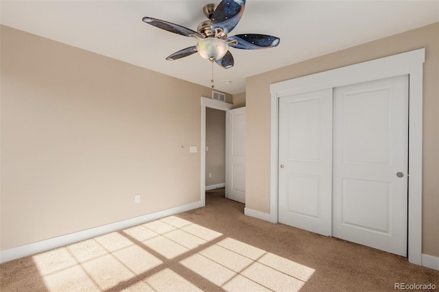 unfurnished bedroom with a closet, ceiling fan, and light carpet