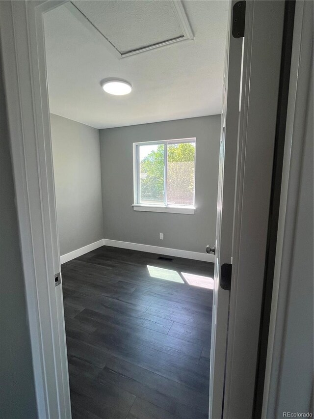 15962 E Exposition Dr, Aurora, CO 80017 - unfurnished room with dark wood finished floors and attic access