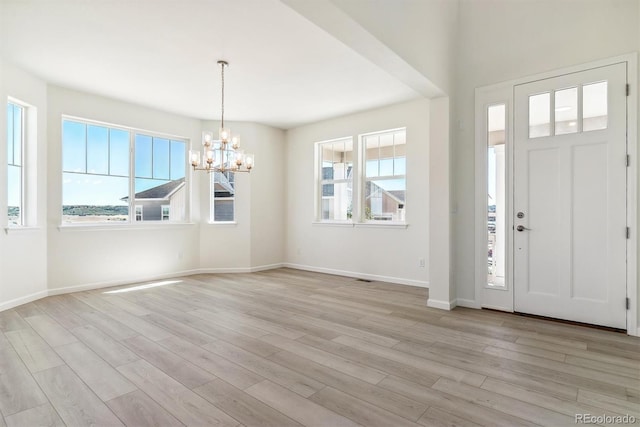 foyer entrance featuring a notable chandelier and light wood-type flooring