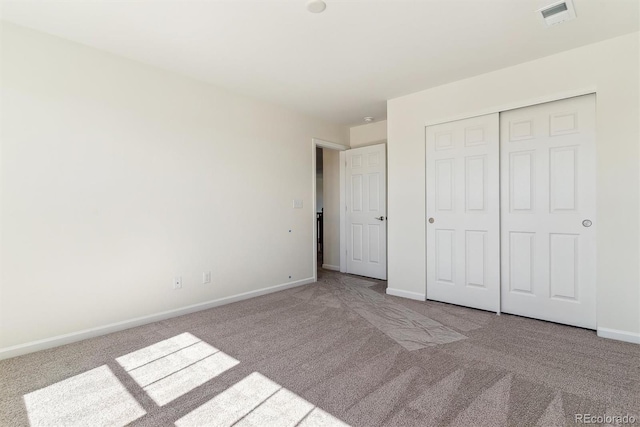 unfurnished bedroom featuring a closet and light colored carpet