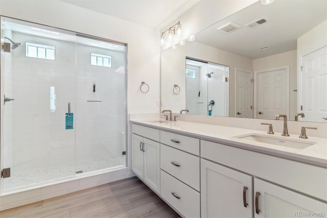 bathroom with hardwood / wood-style floors, vanity, and walk in shower