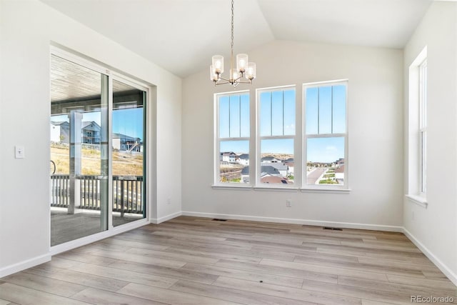 unfurnished dining area featuring a notable chandelier, a wealth of natural light, and vaulted ceiling