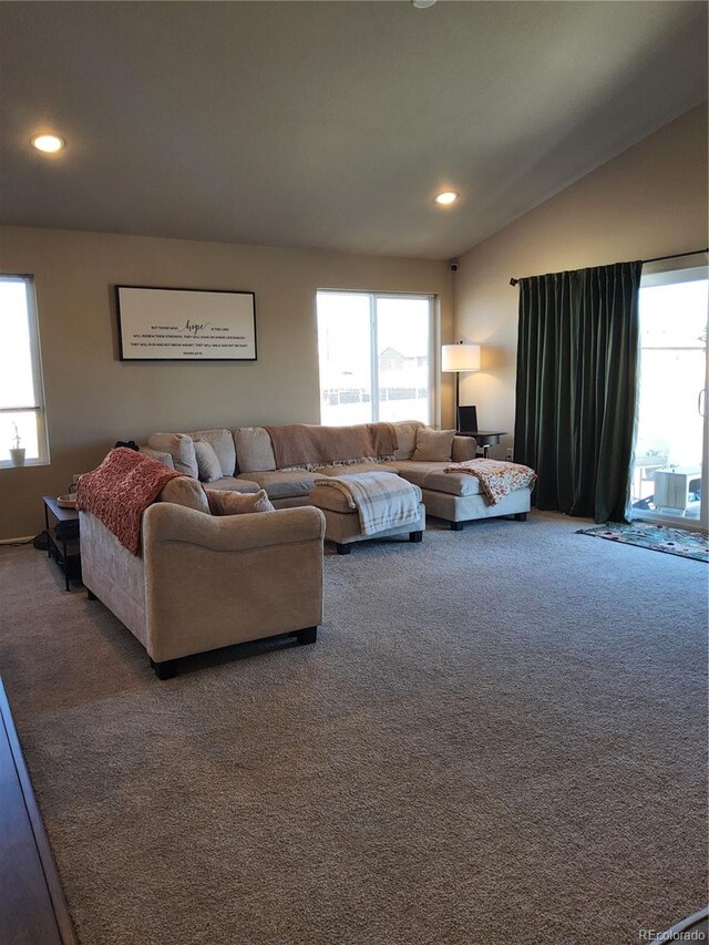 living room with carpet flooring, a wealth of natural light, and lofted ceiling