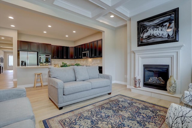 living room featuring coffered ceiling, crown molding, light hardwood / wood-style flooring, and beamed ceiling