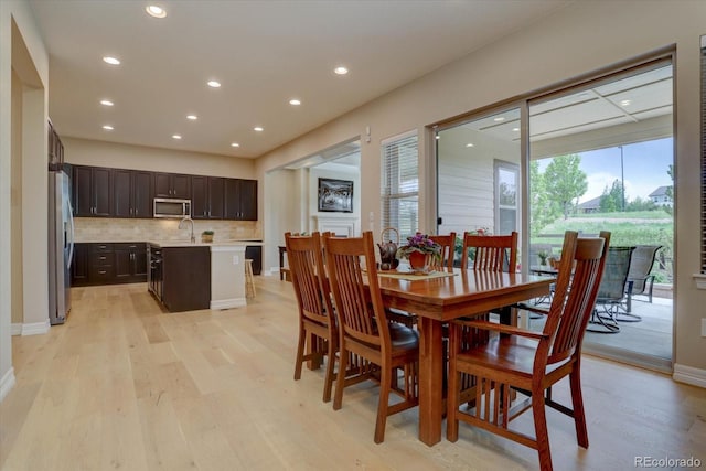 dining space featuring sink and light hardwood / wood-style flooring