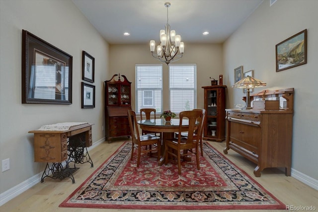 dining room with light hardwood / wood-style floors and a notable chandelier