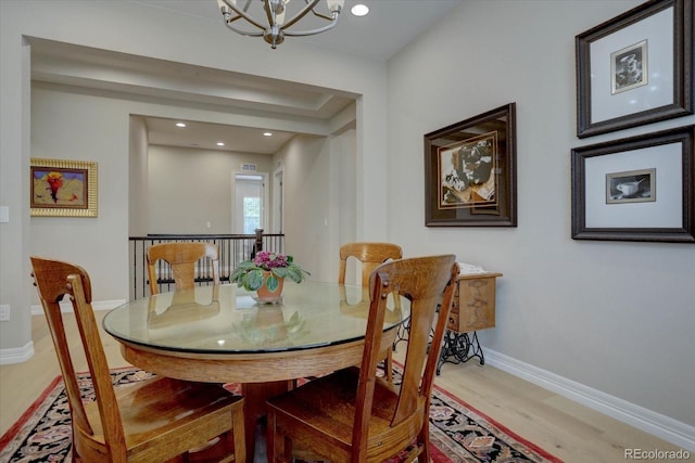 dining space featuring an inviting chandelier and light hardwood / wood-style floors