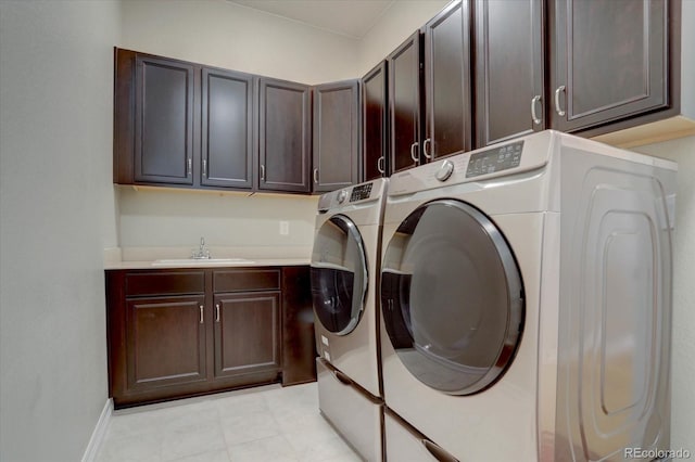 clothes washing area featuring cabinets, sink, and washing machine and clothes dryer