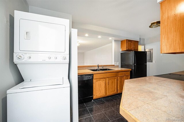 1625 Larimer St Unit 605, Denver, CO 80202 - kitchen featuring black appliances, estacked washer and dryer, brown cabinetry, recessed lighting, and dark tile patterned floors