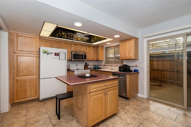 9019 E Oxford Dr, Denver, CO 80237 - kitchen featuring stainless steel appliances, a tray ceiling, dark countertops, recessed lighting, and a kitchen island
