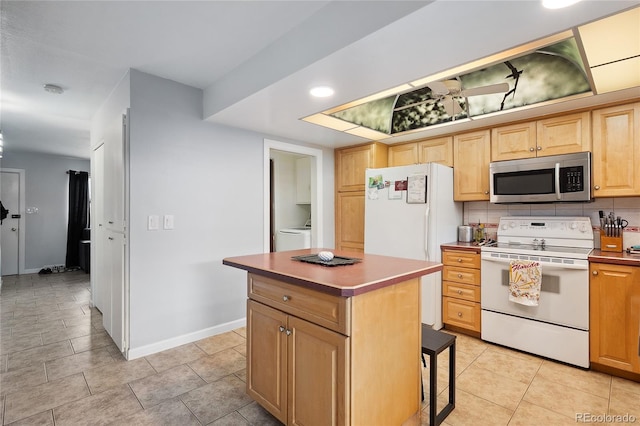 9019 E Oxford Dr, Denver, CO 80237 - kitchen featuring white appliances, a kitchen island, light brown cabinets, baseboards, and light tile patterned floors