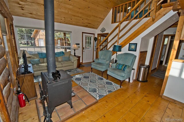 living room featuring hardwood / wood-style floors, a wood stove, vaulted ceiling, and wood ceiling