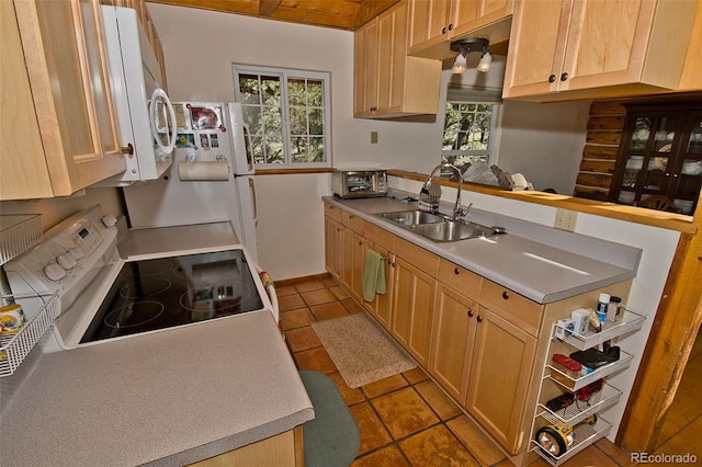 kitchen with sink, white appliances, tile patterned floors, and light brown cabinets