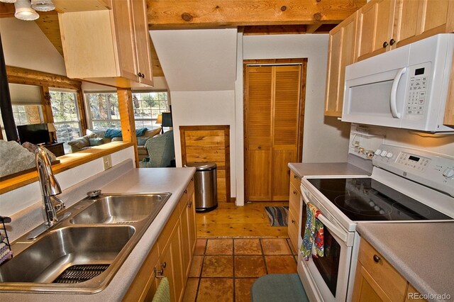 kitchen featuring light brown cabinetry, sink, tile patterned flooring, and white appliances