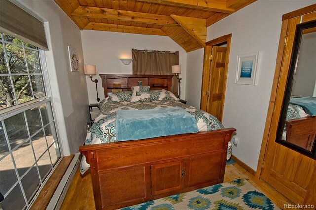 bedroom with light hardwood / wood-style flooring, baseboard heating, wooden ceiling, and lofted ceiling with beams