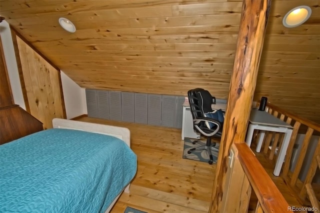 bedroom with lofted ceiling, light wood-type flooring, and wooden walls