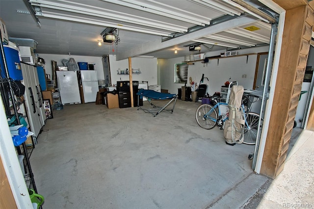 garage featuring white refrigerator and a garage door opener