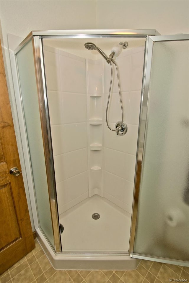 bathroom featuring tile patterned flooring and an enclosed shower