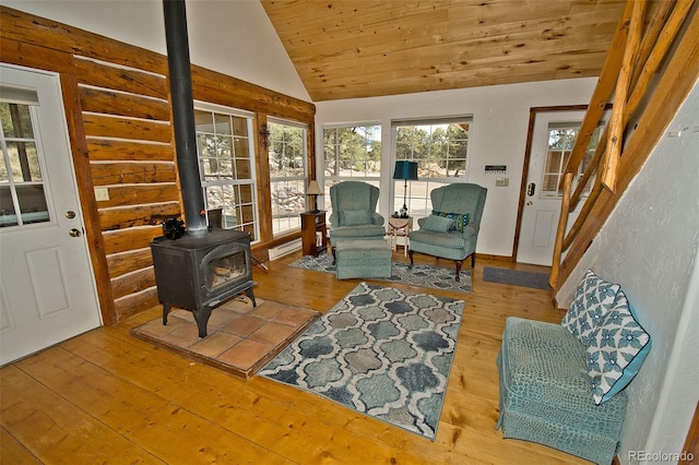 living area with a wood stove, lofted ceiling, stairway, wood ceiling, and hardwood / wood-style flooring