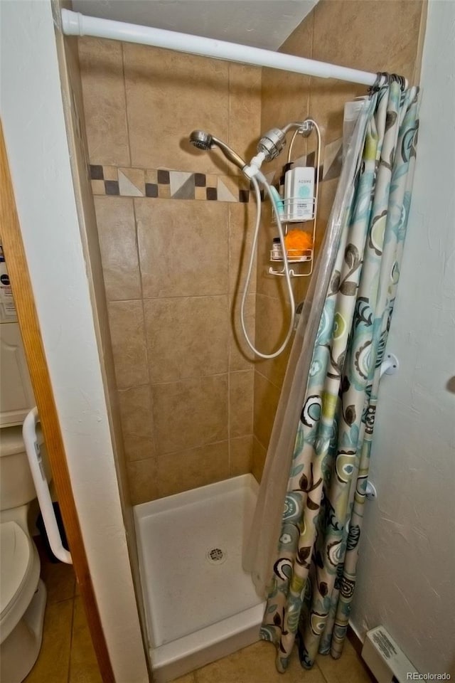 full bath featuring toilet, tile patterned floors, and a shower stall