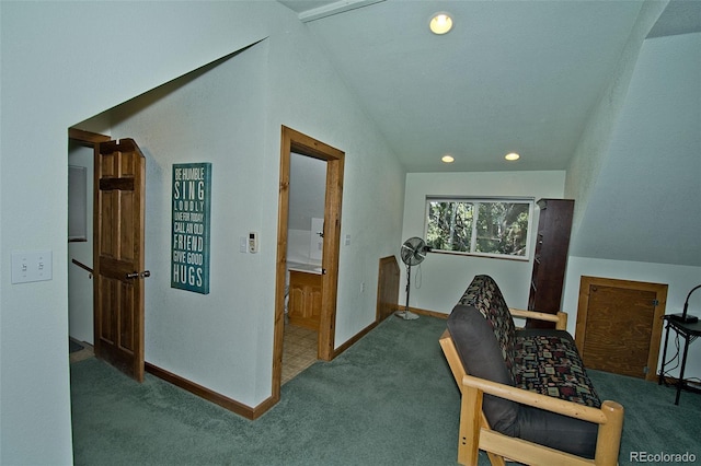 hallway with carpet floors, baseboards, and lofted ceiling