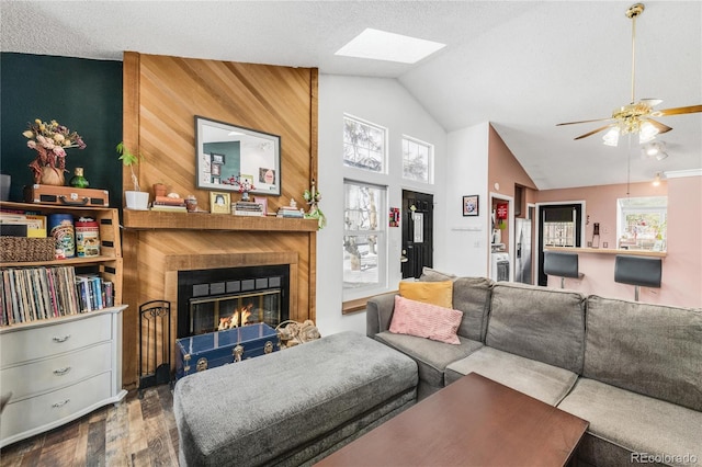 living room featuring wood-type flooring, vaulted ceiling, a textured ceiling, plenty of natural light, and ceiling fan