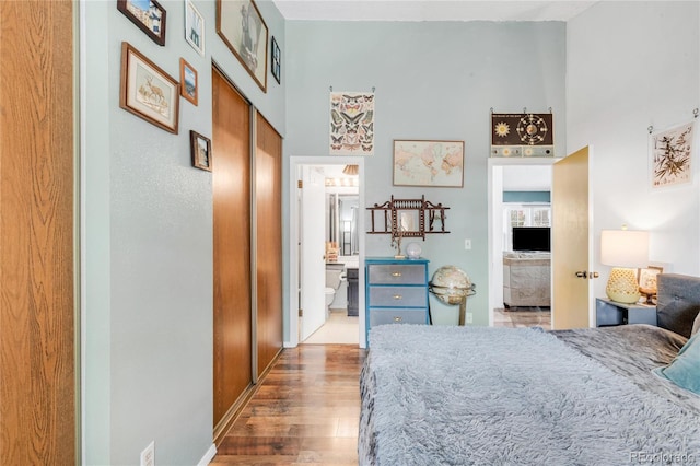 bedroom with hardwood / wood-style floors, connected bathroom, and a closet