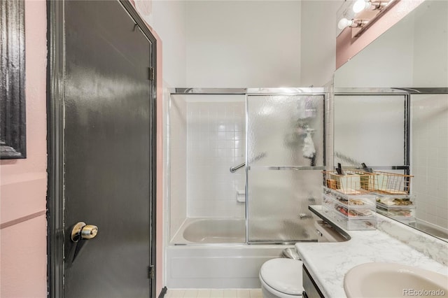 full bathroom with enclosed tub / shower combo, vanity, and toilet