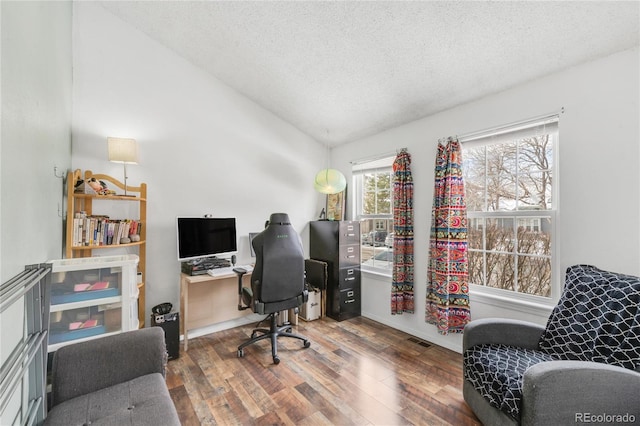 home office with hardwood / wood-style flooring, vaulted ceiling, and a textured ceiling