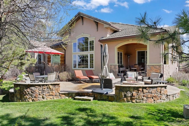 5055 Mcclure Ln, Castle Rock, CO 80108 - rear view of house with an outdoor fire pit, a patio, a lawn, stucco siding, and a tiled roof