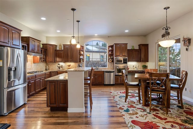 5055 Mcclure Ln, Castle Rock, CO 80108 - kitchen featuring stainless steel appliances, open shelves, healthy amount of natural light, a center island, and recessed lighting