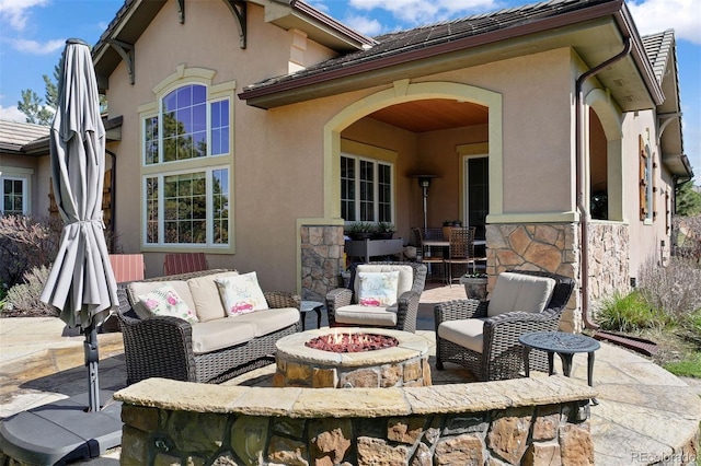 5055 Mcclure Ln, Castle Rock, CO 80108 - back of house featuring stucco siding, a patio, stone siding, and an outdoor living space with a fire pit