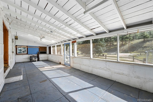 unfurnished sunroom featuring vaulted ceiling with beams