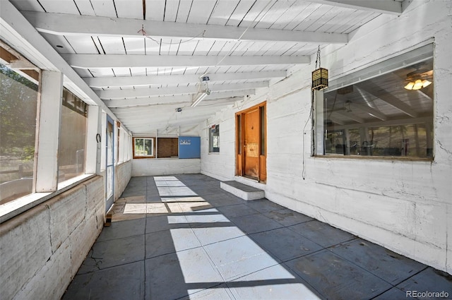 unfurnished sunroom featuring vaulted ceiling with beams and wood ceiling