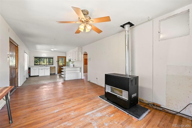 living room with light hardwood / wood-style flooring, heating unit, ceiling fan, and sink