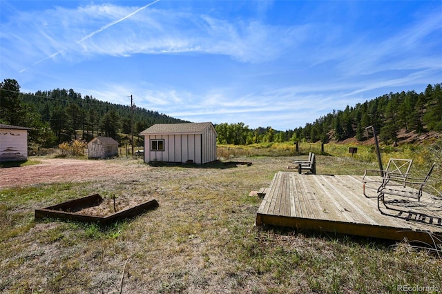 view of yard featuring a wooden deck and a storage unit