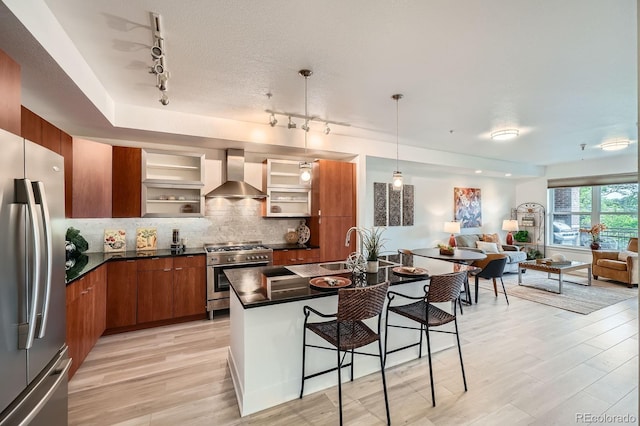 2240 N Clay St Unit 406, Denver, CO 80211 - kitchen featuring stainless steel appliances, wall chimney range hood, rail lighting, and dark countertops