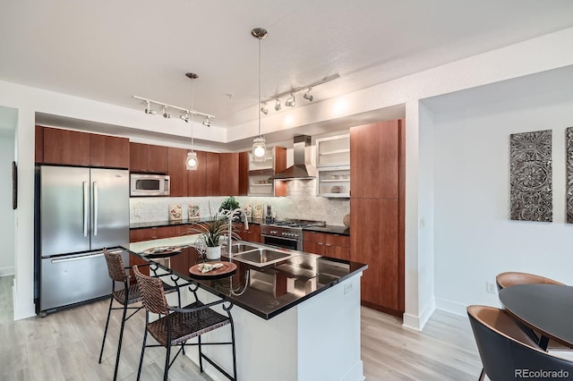 2240 N Clay St Unit 406, Denver, CO 80211 - kitchen featuring stainless steel appliances, wall chimney range hood, dark countertops, and light wood-style floors