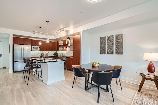 2240 N Clay St Unit 406, Denver, CO 80211 - kitchen with appliances with stainless steel finishes, dark countertops, rail lighting, wall chimney range hood, and a sink